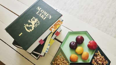 Pöydällä lakikirja ja hedelmiä.